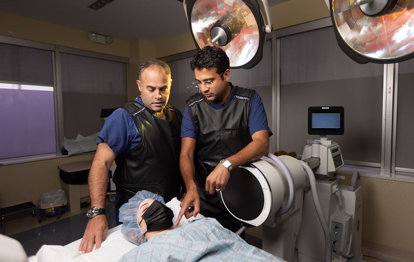 Neurosurgeons Dr. David Wells-Roth and Dr. Harshpal Singh discussing patient's treatment options
